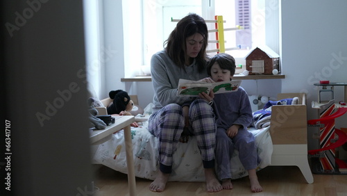 Obraz na płótnie Candid mother telling story to child in bedroom