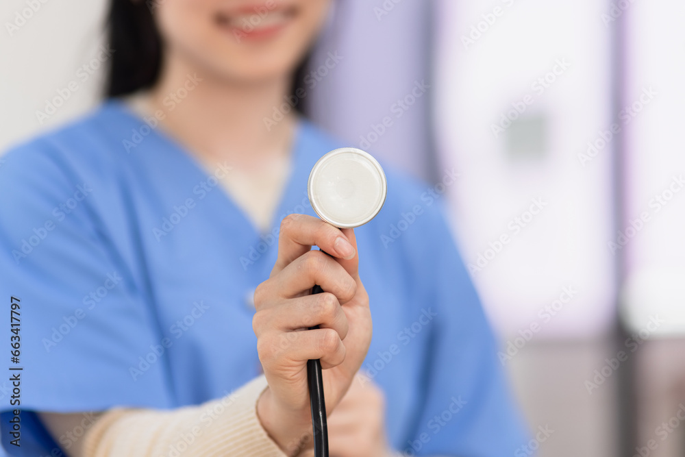 Young Asian female doctor with a stethoscope standing in medical practice. Young Asian female doctor with a stethoscope standing in medical practice.