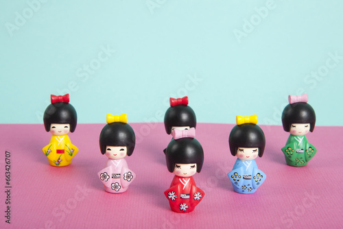 a collection of wooden kokeshi dolls arranged in a triangle like bowling skittles