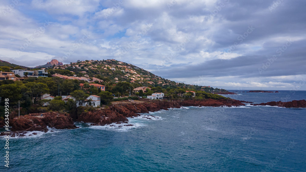 Fototapeta premium Aerial video of the Agay bay on the French Riviera. In the photography can be seen Agay lighthouse and a panorama of the bay, with mountains in the background. Photography was shot on a cloudy day.