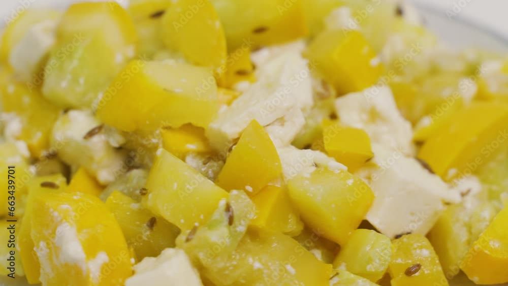 A plate with a prepared dish of zucchini and feta cheese is spinning on the table. View from above. Close-up, presentation. A plate with a prepared dish of zucchini and feta cheese is spinning on the table. View from above. Close-up, presentation.