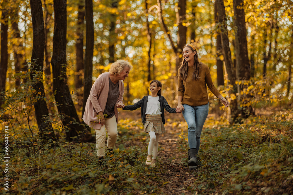 Mother, daughter and grandmother exploring the forest during autumn Mother, daughter and grandmother exploring the forest during autumn