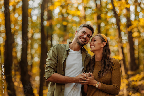 Fotografía Happy couple in love hugging and walking in the forest