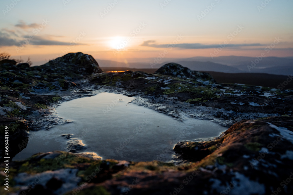 A puddle on a stone from a dew in the mountains, the dawn of the sun in a mountainous area, the reflection of the sky in the water, a stone lake. A puddle on a stone from a dew in the mountains, the dawn of the sun in a mountainous area, the reflection of the sky in the water, a stone lake.