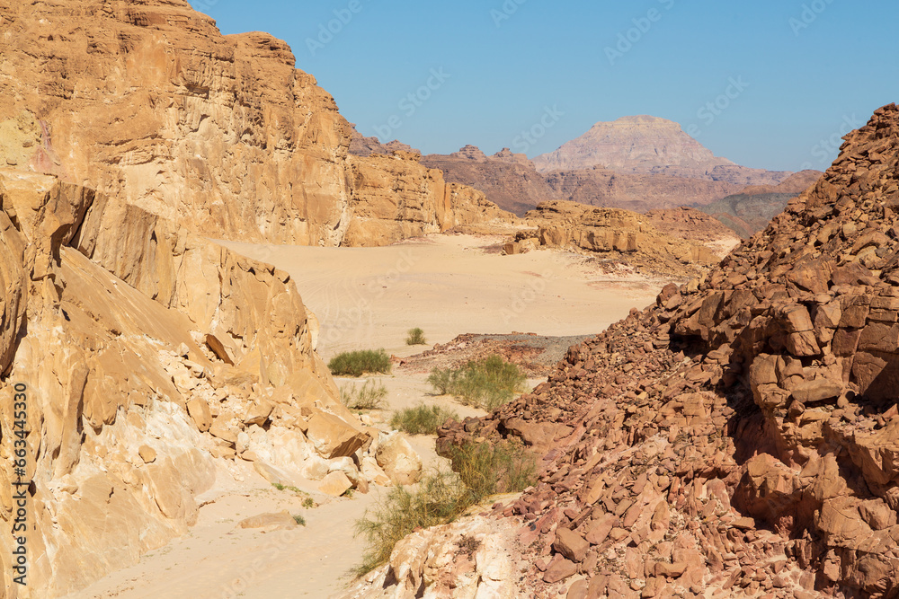Sinai desert. Yellow and orange sandstone textured carved mountain, bright blue sky. Egyptian desert landscape. Sinai peninsula, Egypt Sinai desert. Yellow and orange sandstone textured carved mountain, bright blue sky. Egyptian desert landscape. Sinai peninsula, Egypt