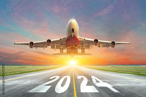 Inscription on the runway 2024 surface of the airport road with take off big airplane enjoy travel sunset sunrise dawn. Concept of travel in the new year, holidays. photo