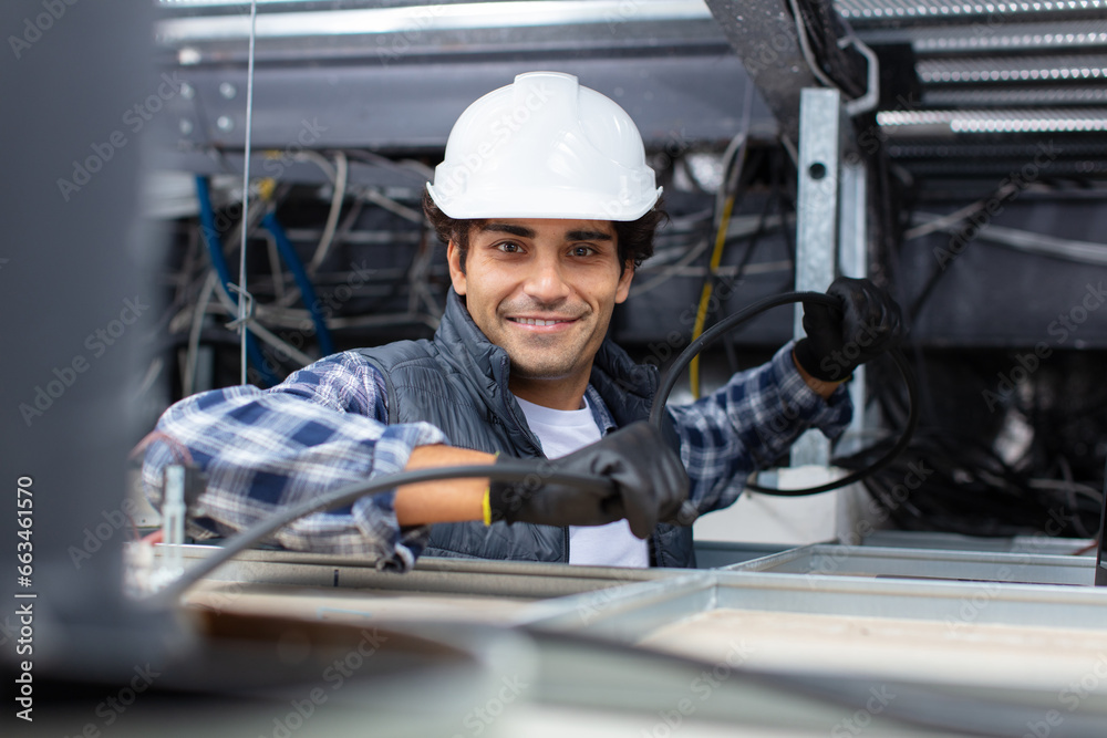 young man electrician wiring inside ceiling young man electrician wiring inside ceiling