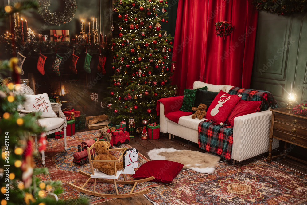 Obraz premium The interior of the room adorned for the holidays features a Christmas tree, presents and a fireplace. The room is filled with the warm glow of festive lights, creating a cozy and magical atmosphere