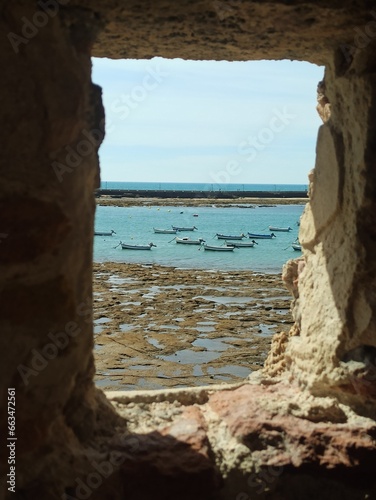 Vistas desde el Castillo de Santa Catalina. Marea baja , vistas de pequeños barcos pesqueros y de la playa de la Caleta. Cádiz. Andalucía. España.
