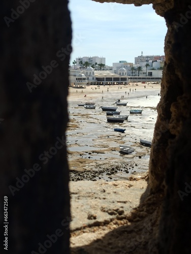 Vistas desde el Castillo de Santa Catalina. Marea baja , vistas de pequeños barcos pesqueros y de la playa de la Caleta. Cádiz. Andalucía. España.