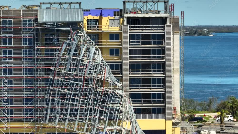Aerial view of ruined by hurricane Ian construction scaffolding on high apartment building site in Port Charlotte, USA