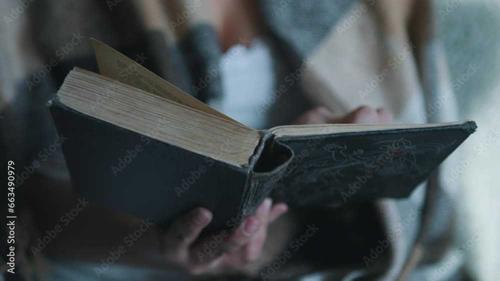 Female hands turning pages. Woman under cozy blanket reading book. Close up. Female hands turning pages. Woman under cozy blanket reading book. Close up.