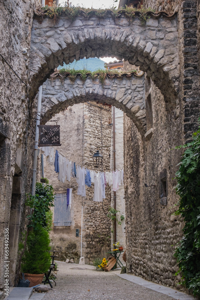 Village scene with laundry hanging on a clothesline in a narrow street of the charming medieval village of Chatillon en Diois in the south of France (Drome)