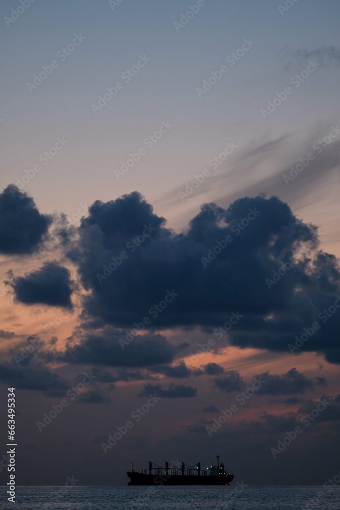 Fototapeta premium Ship at sunset, cloudy evening