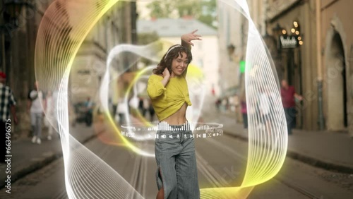 A young woman in a bright top and jeans dances on the street to music from her headphones, with impressive holographic effects, enhancing her musical experience photo