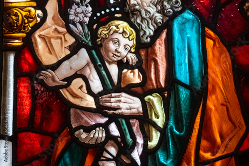 Beautiful stained glass window with a religious image of the baby Jesus, colorful and translucent in a church.