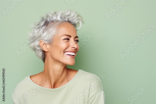 Portrait of a happy senior woman smiling at the camera over green background