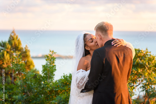 Happy newlyweds hugging against the backdrop of a seascape