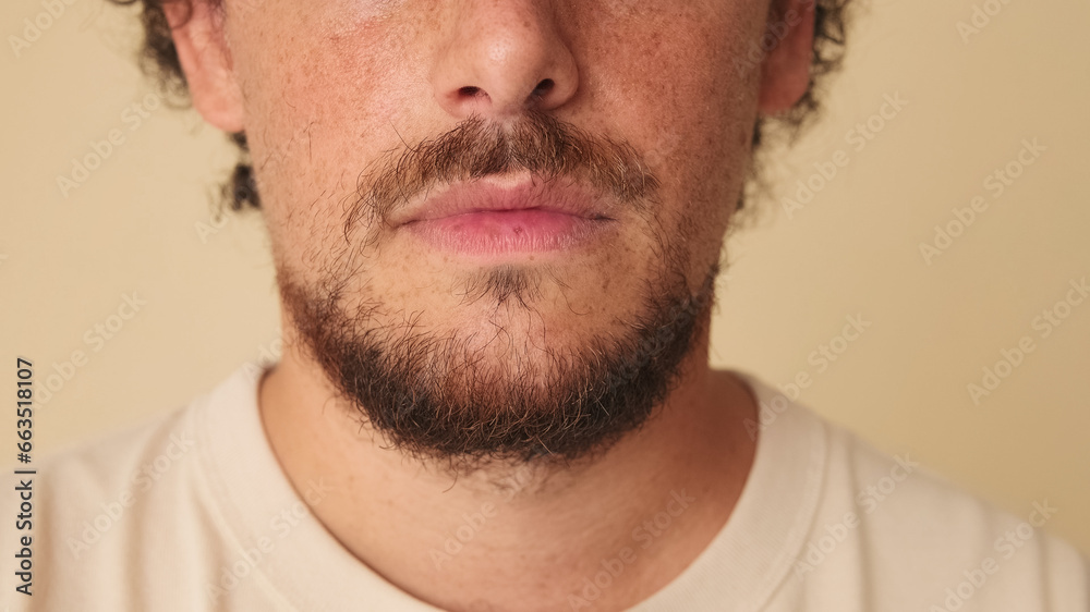 Fototapeta premium Detailed close-up shot of man's face in studio on beige background