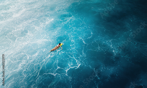 Woman surfer in a deep ocean on a short surfboard in Hawaii aerial