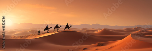 A Camel Caravan Moves Through the Vast Expanse of the Sahara Desert with Sunset in Background photo