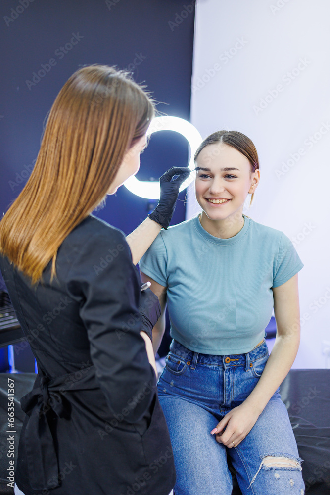 Fototapeta premium Marking a woman's face before permanent eyebrow makeup. Eyebrow tattoo. Beauty procedure for a woman's face