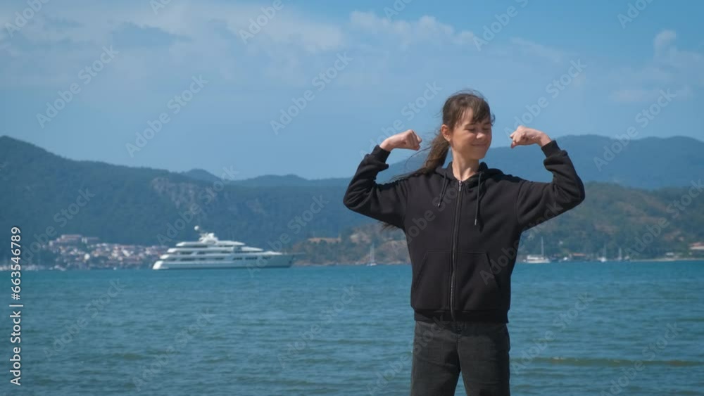 Sporty teen on piers. An active teen girl relax on the beach and show her muscles by the sunny beach. Sporty teen on piers. An active teen girl relax on the beach and show her muscles by the sunny beach.