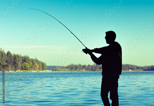 silhouette of man fishing on the lake
