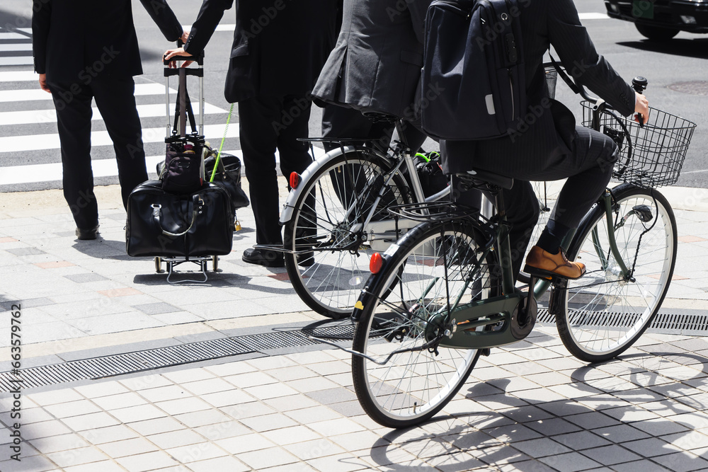 Japanese business men on bicycles on the sidewalk in Tokyo Japanese business men on bicycles on the sidewalk in Tokyo