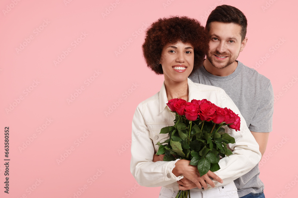 International dating. Lovely couple with bouquet of roses on pink background. Space for text