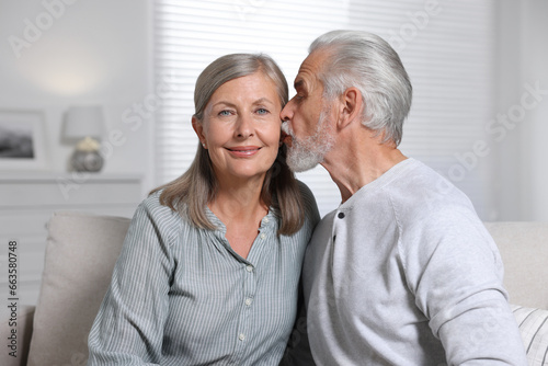 Senior man kissing his beloved woman at home
