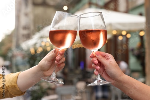 Women clinking glasses with rose wine outdoors, closeup © New Africa