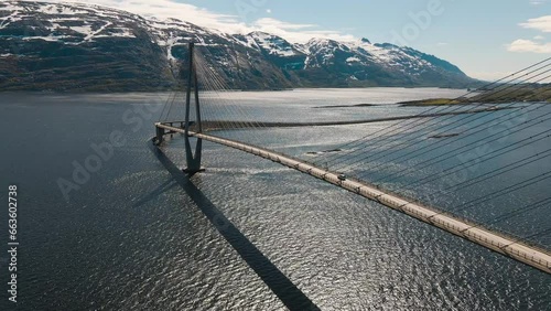 4K drone wide shot with parallax motion of calm fjord and the majestic bridge in Helgeland, a famous tourist attraction on the Norwegian scenic tourist route Helgelandskysten, Helgelandsbrua, Norway. photo