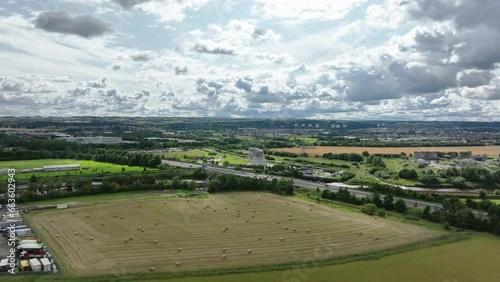 4K wide aerial push in towards the The Kelpies, the largest quine sculptures in the world. Edinburgh, the Capital of Scotland, United Kingdom. Farmland and freeway in the foreground. photo