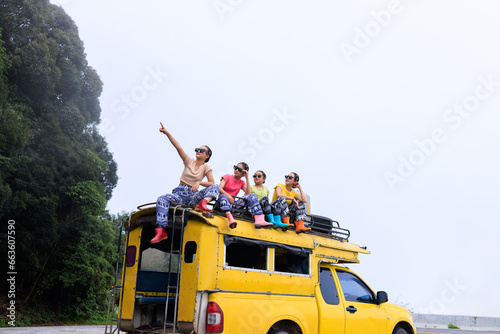  teenager girl friends group sitting on the roof of yellow a minibus, chiamg mai thailand, amazing travel tourist concept, photo