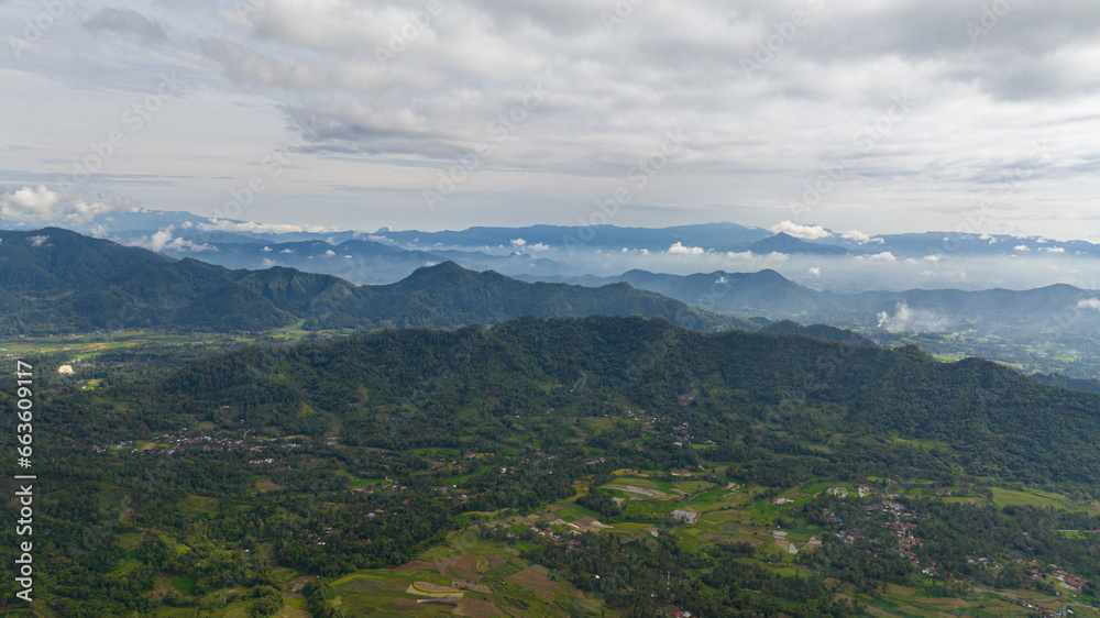 Aerial drone of farmland with plantings and mountains. Farmland in the tropics. Bukittinggi, Sumatra. Indonesia. Aerial drone of farmland with plantings and mountains. Farmland in the tropics. Bukittinggi, Sumatra. Indonesia.