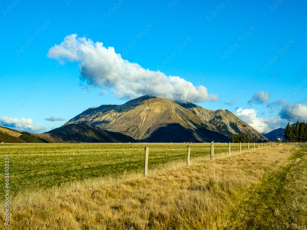Fototapeta premium Mountain and clouds beside country road