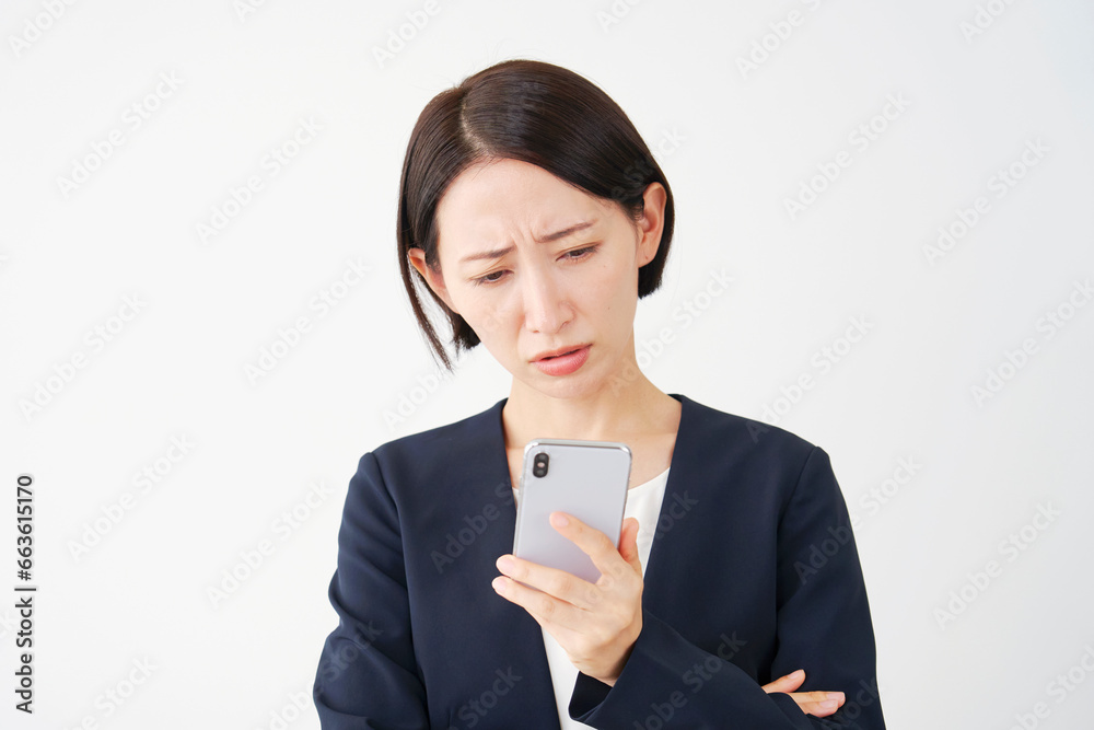スマートフォンを見て悩むビジネスウーマン　白背景