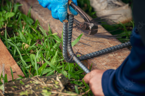 Construction Worker hands using pincer pliers iron wire. Outdoor Worker using wire bending pliers, construction work. Men hands bending cutting steel wire fences bar reinforcement of concrete work