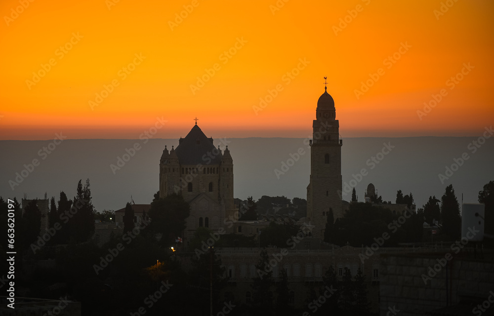 Fototapeta premium Dramatic sunrise in Israel. Synagogue view from above against orange sky and mountains line background. Sunrise view in Jerusalem, concept image for this war times.