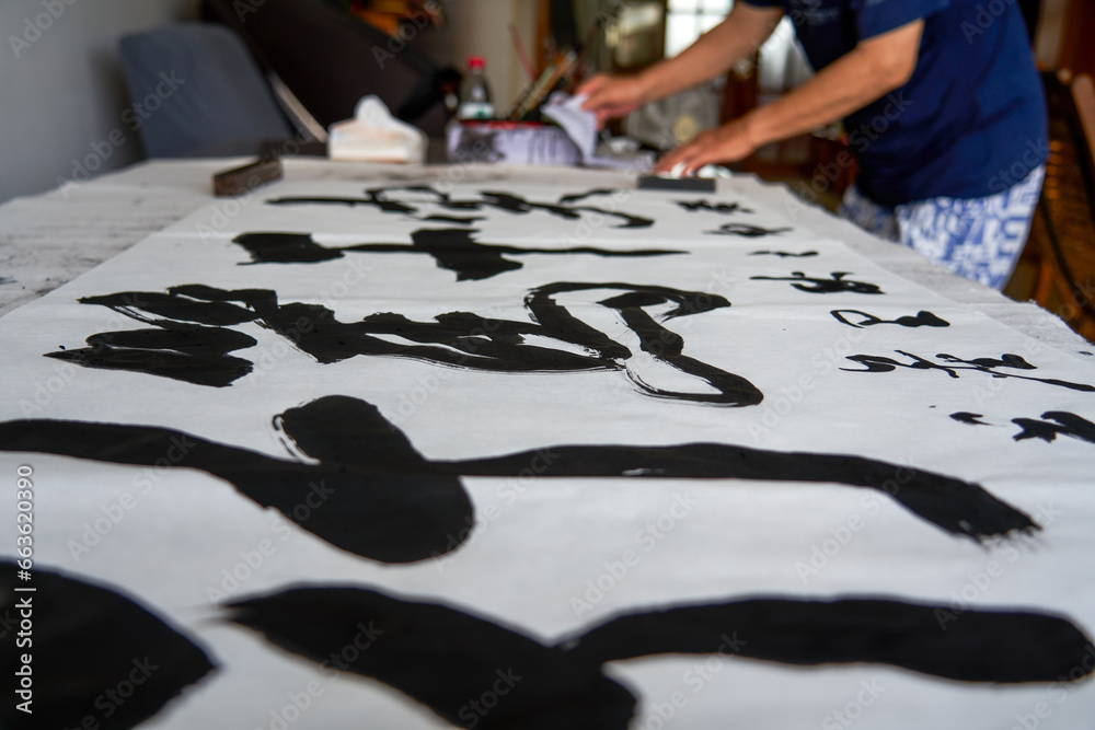 Fototapeta premium A Chinese calligrapher writes calligraphy and creates a calligraphy work