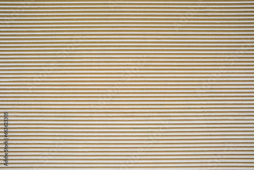 Fototapeta Naklejka Na Ścianę i Meble -  Background from a beige plastered wall with a corrugated profile