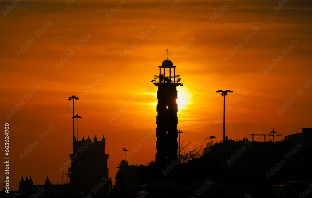 Landmark sunset photo in Lisbon. Amazing view of the fortress and lighthouse of Lisbon during a summer sunset with spectacular sky. Travel to Portugal.