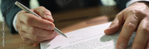 Businessman puts personal signature on contract paper sheet