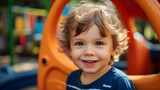 Portrait of happy little boy on outdoor playground in kindergarten, happy child, lifestyle.