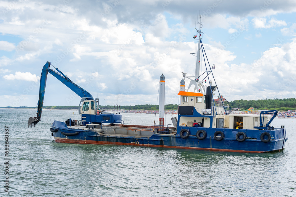 ship with excavator for dredging the entrance to the port