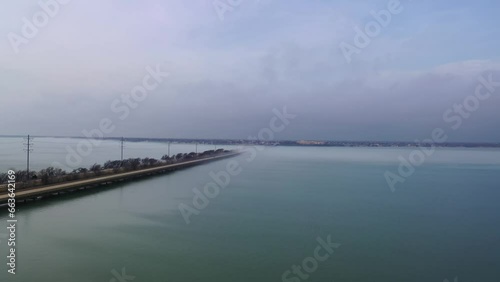 Wallpaper Mural Aerial dolly along highway bridge crossing large body of water, cityscape covered in fog in the distance Torontodigital.ca