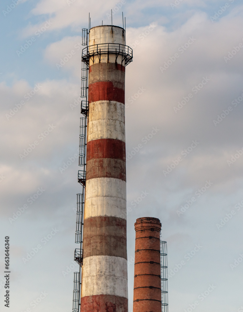 Pipe at an industrial plant against the background of the sky with clouds Pipe at an industrial plant against the background of the sky with clouds
