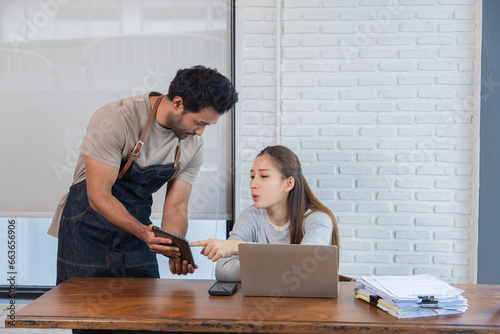 Beautiful female customer ordering food with waiter in restaurant. Indian male waiter taking orders from customers and Offer food recommen or new menu of shop. Restaurant small business owner concept. photo