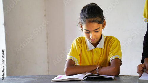 Indian school child sitting at desk in classroom with notebooks writing test Elementary school, Education concept. photo